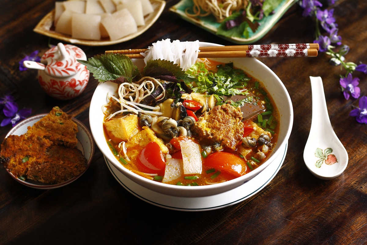 The signature broth combines freshwater crab stock with tomatoes, creating the characteristic color and flavor